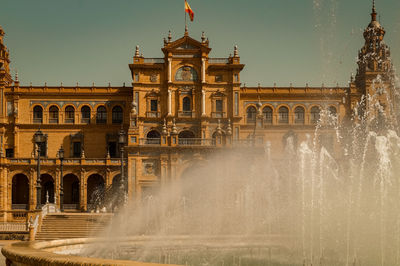 View of fountain in city against clear sky