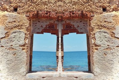 View of old building by sea against sky