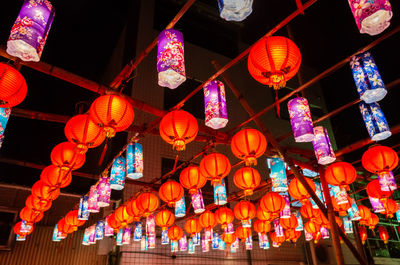 Low angle view of illuminated lanterns hanging at night