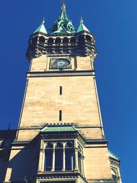 Low angle view of bell tower against clear blue sky