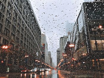City street seen through wet glass window during rainy season