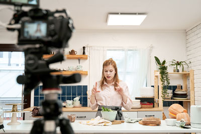 Portrait of woman holding food at home