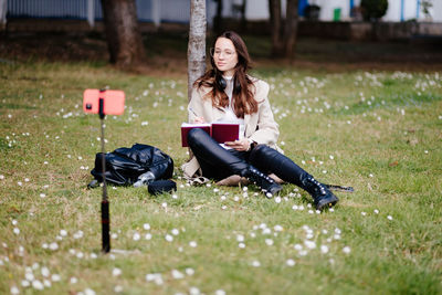 Portrait of young woman sitting on field