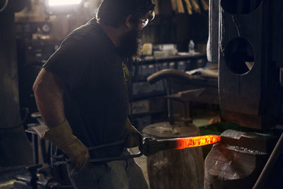 Blacksmith forging rod at workshop