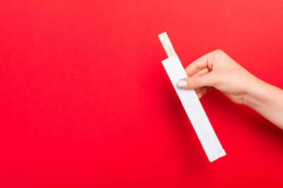 Close-up of hand holding red paper