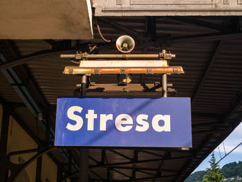 Low angle view of information sign against blue sky