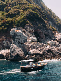 Boats in sea boat passing the coast of capri,italy