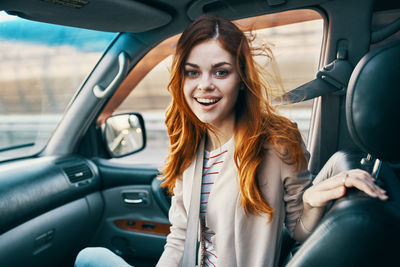 Portrait of smiling young woman in car