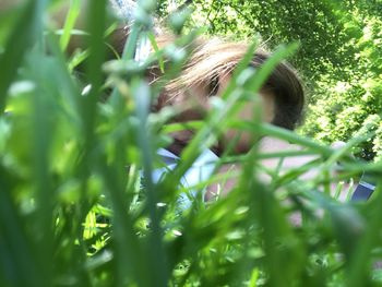 Close-up of girl on plant in field