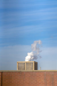 Smoke emitting from chimney against sky