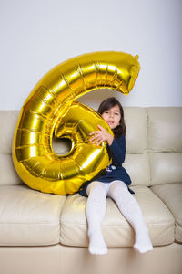 Portrait of young woman sitting on sofa