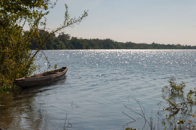 Boat moored in lake against sky