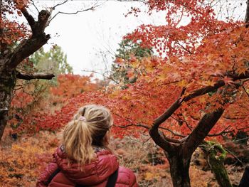 Rear view of girl standing in forest during autumn