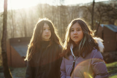 Portrait of smiling young girls standing against trees