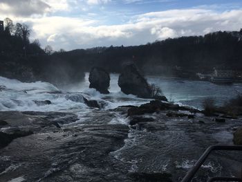 Scenic view of waterfall against sky