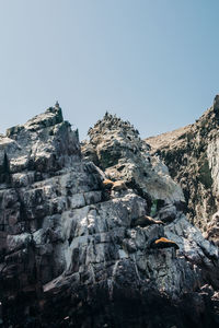 Low angle view of rocks against clear sky