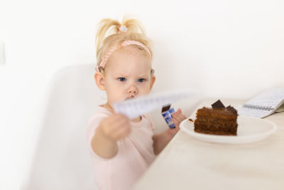 High angle view of cute girl eating food on table