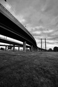 Low angle view of bridge on field against sky