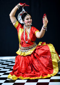 Full length of woman standing against wall