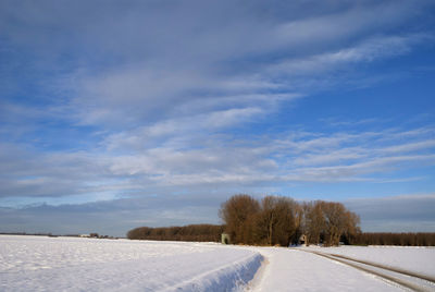 Scenic view of snow covered field against sky