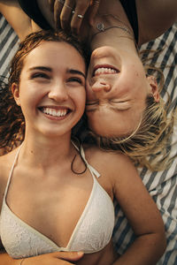 Directly above view of happy female friends lying down together during vacation