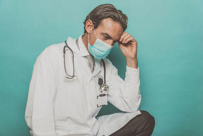 Doctor wearing mask against colored background