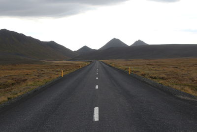 Empty road leading towards mountains