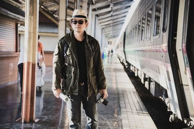 Man standing on train at railroad station