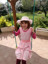 Portrait of happy girl enjoying swing