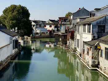 Buildings by lake against sky