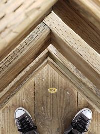 Low section of person standing on wooden floor