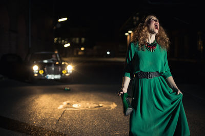 Woman standing in illuminated city at night