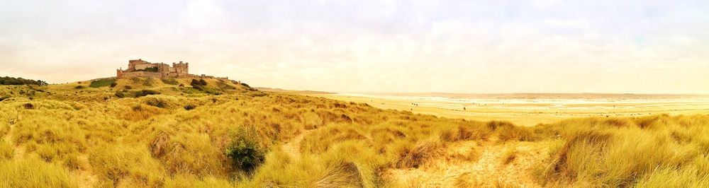 Scenic view of land against sky. bamburgh castle. northumberland. uk