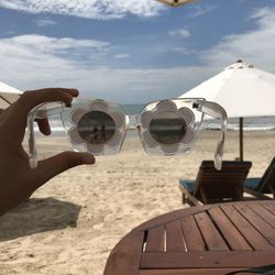 Close-up of sunglasses on beach against sky