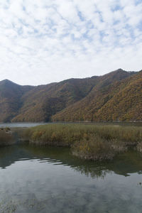 Scenic view of lake and mountains against sky