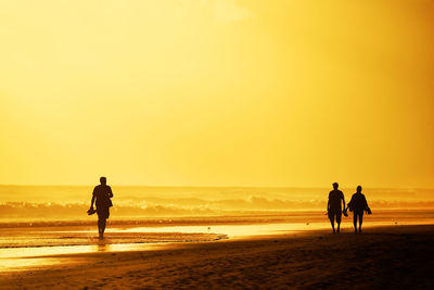 Tourists visiting beach against sky