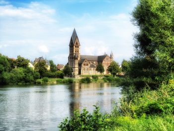 Historic building by lake against sky