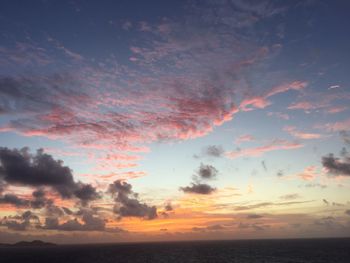 Scenic view of sea against dramatic sky during sunset