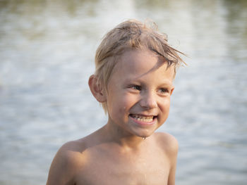Close-up of shirtless boy at lakeshore