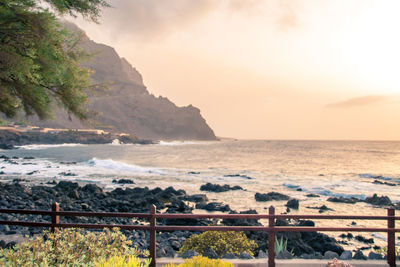 Scenic view of sea and mountains against sky