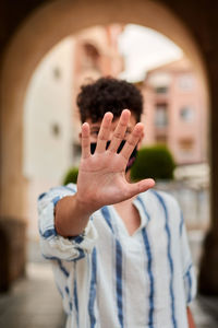 Young man with a mask and his hand up. concept of social distance