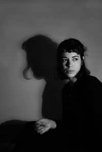 Young woman standing against wall