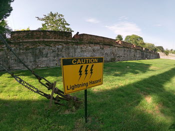 Information sign on field against sky