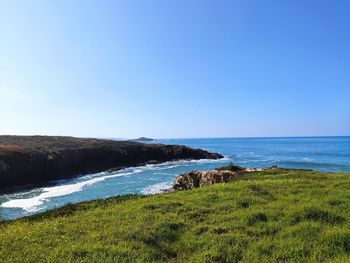 Scenic view of sea against clear blue sky