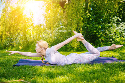 Side view of woman sitting on grass