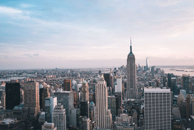 Empire state building amidst cityscape against sky