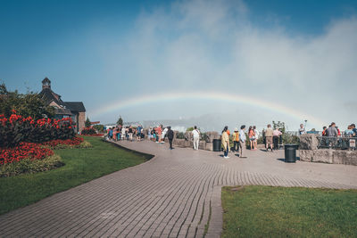 People on landscape against cloudy sky