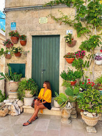 Woman sitting by potted plant