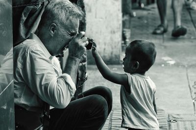 Man photographing boy on footpath