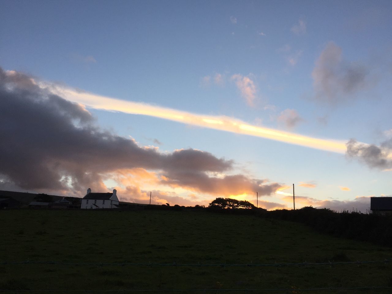 silhouette, landscape, sunset, scenics, tranquil scene, sky, tranquility, beauty in nature, dark, outline, calm, cloud, blue, nature, field, rural scene, cloud - sky, outdoors, vapor trail, majestic, non-urban scene, remote, no people, farmhouse, agriculture